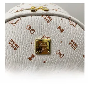Close-up of white lychee leather backpack with golden brand plaque and cute cat print