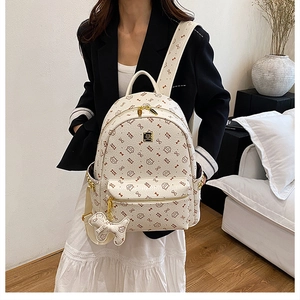 Detail of printed white PU leather backpack with cat motifs and gold zippers