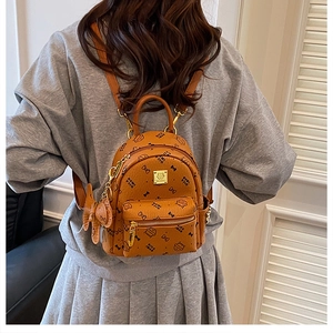 Close-up of brown mini cat print backpack with gold zipper and bow charm detail