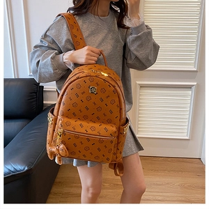Detail of fashion brown backpack with cat print pattern and cute bear charm pendant