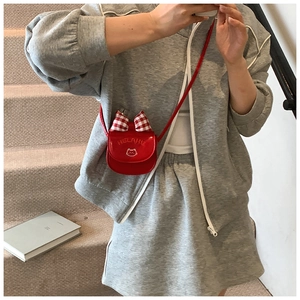 Detailed view of red mini kitty crossbody bag with plaid bow and white cat embroidery