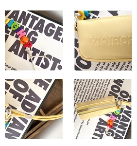 Close-up of yellow PU leather mini pouch with colorful letter beads and metal zipper
