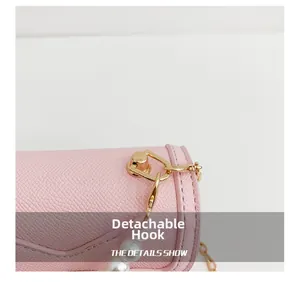 Detail of pink litchi leather bag with gold detachable hook and large pearl chain