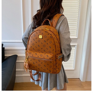 Detail of a brown printed backpack with cute cat patterns and gold rivet accents