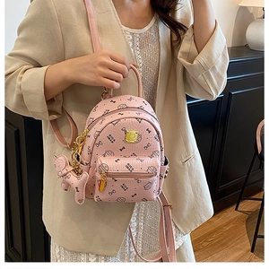 Pink mini backpack detail featuring cartoon prints and a cute plush dog pendant accessory