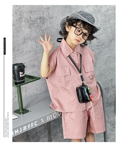 Close-up of a pink kids' outfit with a trendy mini neck bag for a stylish casual look