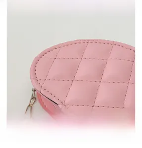 Détail du sac rose en forme de cœur montrant le similicuir matelassé et la chaîne