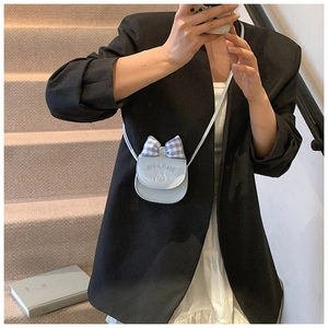 Detailed view of mini blue shoulder bag with plaid bow and cute cat graphic on strap