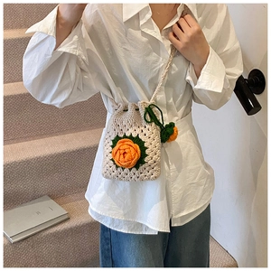 Details der handgefertigten Häkel-Schultertasche mit 3D-Blumen und Kordelzugverschluss