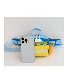 Detailvergleich der mehrfarbigen Kinder-Umhängetasche neben einem Smartphone