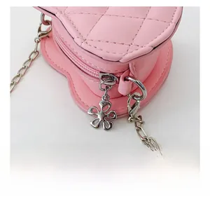 Détail du sac rose en forme de cœur avec motif matelassé, chaîne argentée et zip floral
