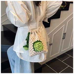 Detail der gehäkelten Beuteltasche mit grüner 3D-Blume und Kordelzug-Verschluss