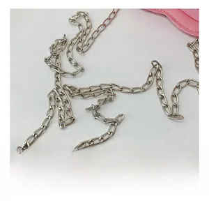 Close-up of durable silver metal chain strap and pink leather stitching on small handbag