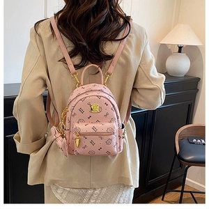Close-up of pink mini backpack with cat print and metallic hardware on female model