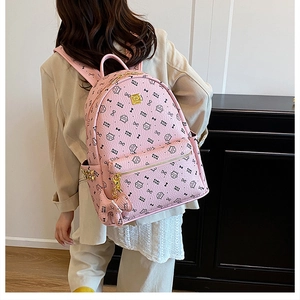 Detail view of pink leather backpack with cute black cat print and golden hardware