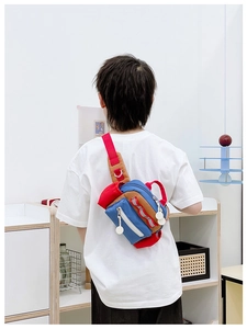 Rückansicht eines Kindes mit bunter Patchwork-Brusttasche aus Nylon in häuslicher Umgebung
