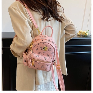 Pink cat pattern mini backpack in pebble PU leather worn over a beige blazer