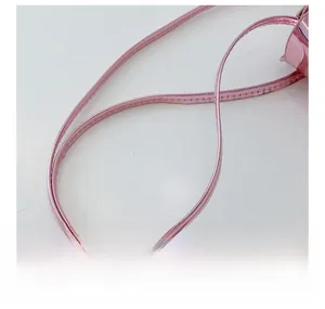 Close-up of pink metallic leather shoulder strap with neat stitching for fashion bags