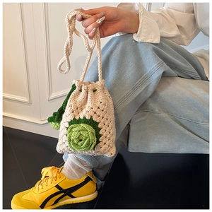 Detail einer handgehäkelten Kordelzug-Beuteltasche mit großer 3D-Blume und Schultergurt