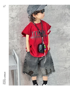 Close-up of kids red street fashion t-shirt with fringe sleeves and denim shorts detail