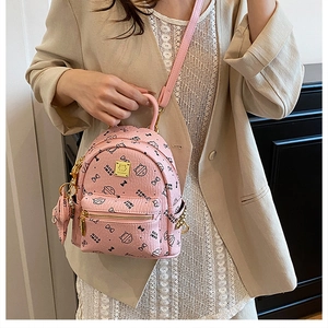 Close-up of pink cat pattern backpack showing textured leather and gold hardware