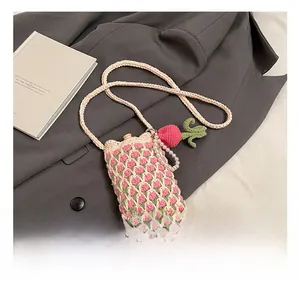 Détail du sac à téléphone en crochet tulipe avec chaîne en perles sur fond gris