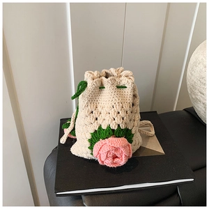 Detail der handgewebten Kordelzug-Beuteltasche mit rosa Blumen und grünen Trägern