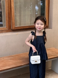 Detail of a white mini pearl handbag with heart design for toddler princess outfits