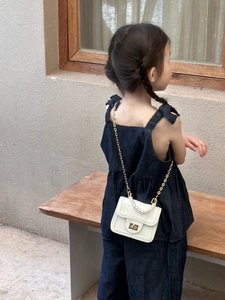 Close-up of white mini girl handbag with pearl handle and golden chain strap