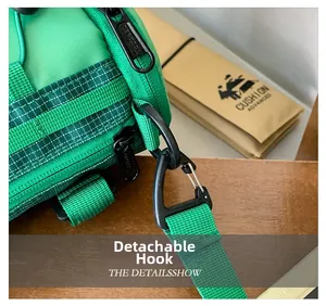 Détail du crochet amovible et de la sangle en nylon vert du sac bandoulière garçon