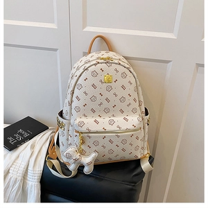 Detail of white lychee textured backpack with cat monogram print and gold zipper front pocket