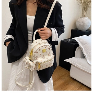 Detail of white mini backpack with cute cat prints and gold zippers on model