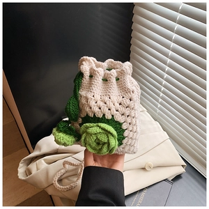 Details der handgefertigten Häkeltasche mit grüner Blume und Kordelzugverschluss