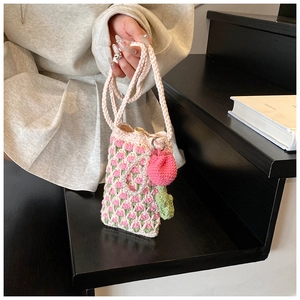 Détail du sac de téléphone crocheté tulipe avec chaîne perle et breloque fraise