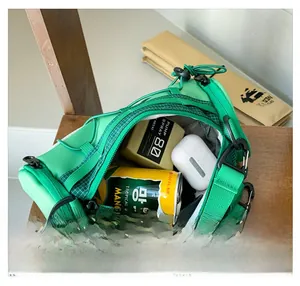 Vue intérieure du sac bandoulière enfant vert montrant le rangement des objets
