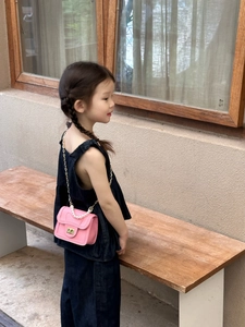 Pink princess mini bag with pearl handle and metal chain shown on a child model