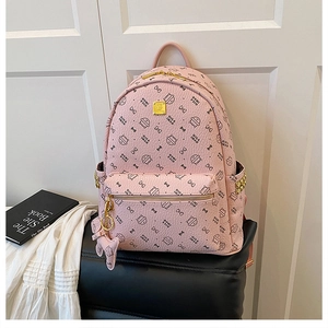 Close-up of pink backpack with cat print patterns and golden metal logo details