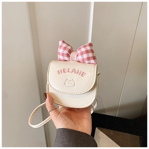 Close-up of cream leather mini bag with pink plaid bow and cute cat embroidery