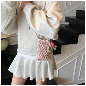 Détail du sac à bandoulière au crochet avec motif de tulipes et charm fraise mignon