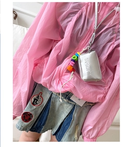 Kids silver metallic mini neck pouch with colorful beaded charms on trendy outfit