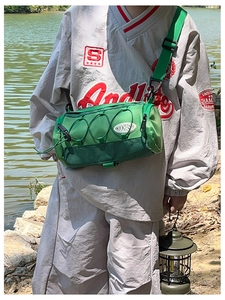 Détail du sac cylindrique en nylon vert avec cordons élastiques et sangle réglable