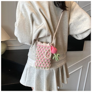 Détail du sac à téléphone crocheté avec motif tulipe, chaîne en perles et breloque fraise