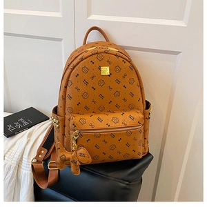 Close-up of brown PU leather backpack featuring cat motif monogram and metal studs