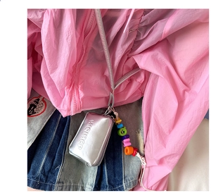 Detail of silver metallic kids neck bag with colorful letter beads and zipper