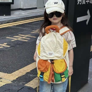 Outdoor street shot of kids patchwork backpack with colorful panels and fashion labels