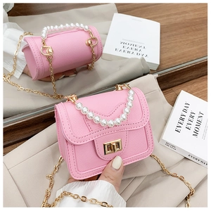 Detailed macro view of pink litchi grain mini bag with pearl handle and gold chain