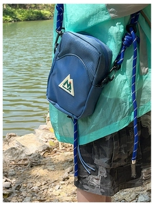 Détail d'un sac bandoulière bleu en nylon résistant à l'eau avec bandoulière en corde tissée