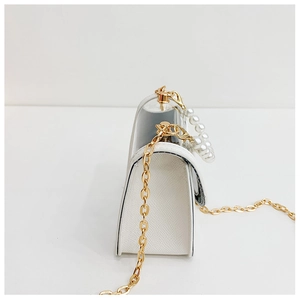 Détail du grain croisé blanc avec poignée en perles et bandoulière en chaîne dorée