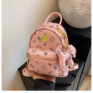 Detailed close-up of pink mini cat print backpack with golden zippers and bow charm