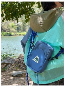 Détail du sac bandoulière bleu pour enfants avec sangle en corde et patch montagne